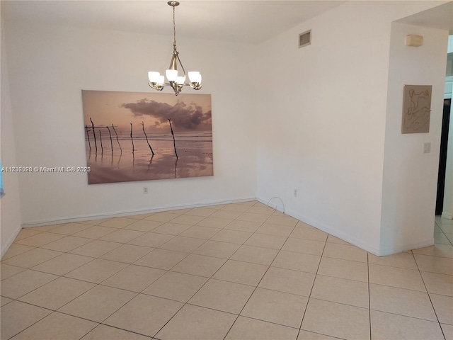 tiled empty room with a chandelier