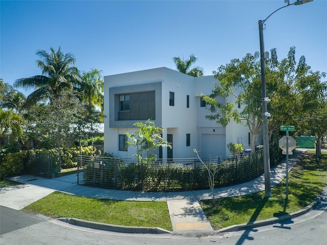 modern home with a fenced front yard and stucco siding