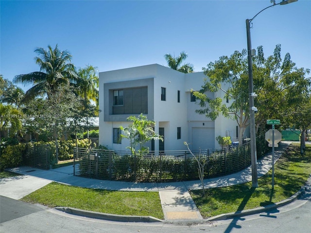 modern home featuring stucco siding and a fenced front yard