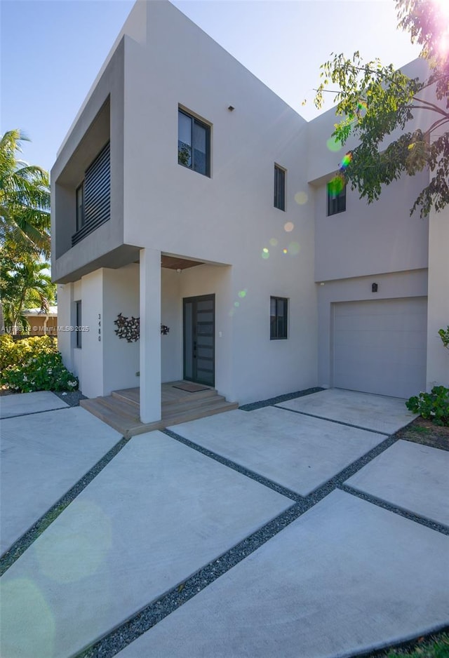 view of front of property with a garage, driveway, and stucco siding