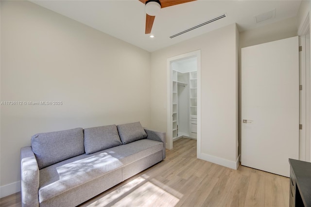 living area featuring visible vents, light wood finished floors, baseboards, recessed lighting, and attic access