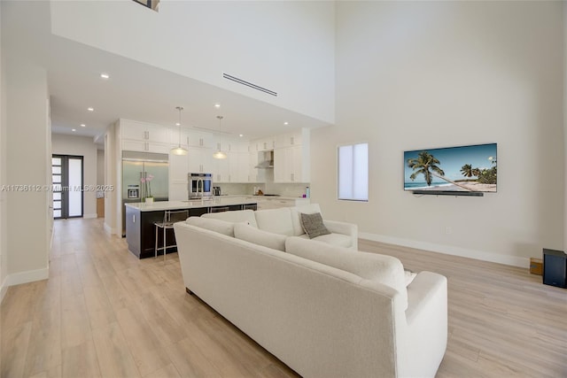 living room featuring light hardwood / wood-style flooring and a high ceiling