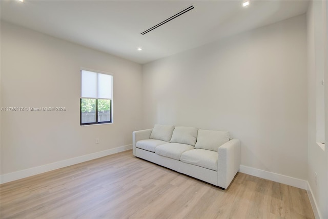 living area featuring baseboards, light wood-style floors, and recessed lighting