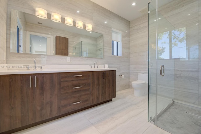 bathroom featuring a stall shower, tile walls, toilet, and a sink