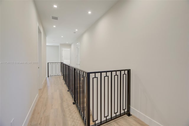 hallway featuring an upstairs landing, visible vents, light wood-style flooring, baseboards, and recessed lighting