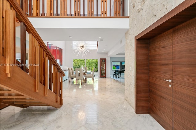 1251 Kane Concourse, Bay Harbor Islands, FL 33154 - entrance foyer featuring a high ceiling, light marble finish floors, a chandelier, and stairway