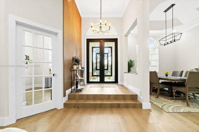 entryway with an inviting chandelier, hardwood / wood-style floors, and french doors