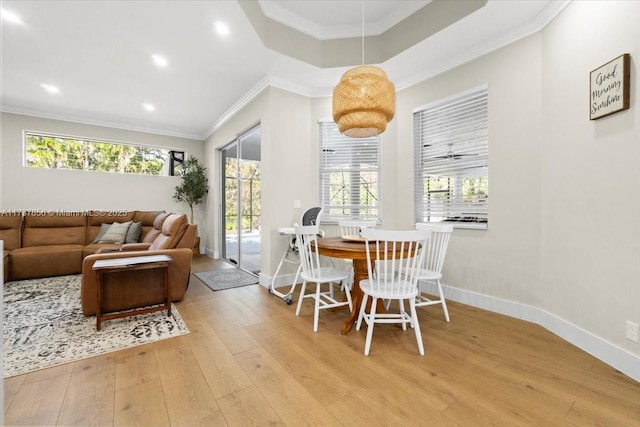 dining area with ornamental molding and light hardwood / wood-style floors