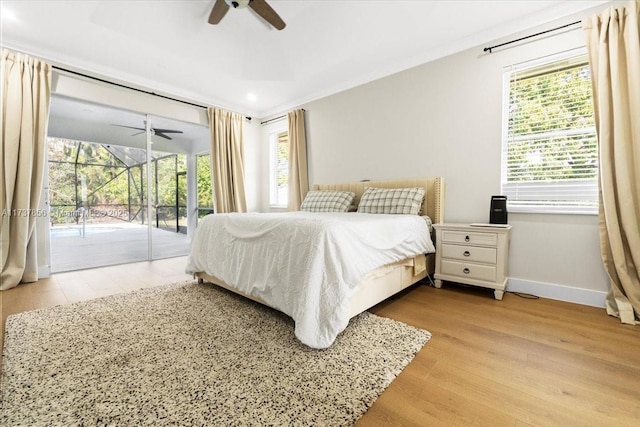 bedroom featuring multiple windows, crown molding, access to outside, and light wood-type flooring