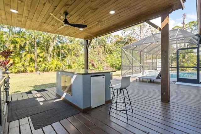 wooden terrace featuring glass enclosure and a bar