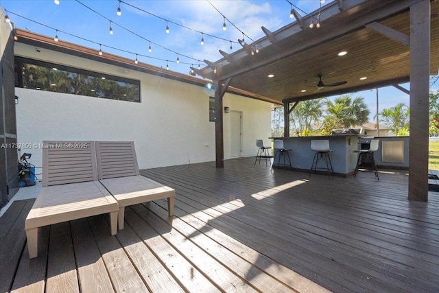 wooden terrace featuring an outdoor bar and ceiling fan