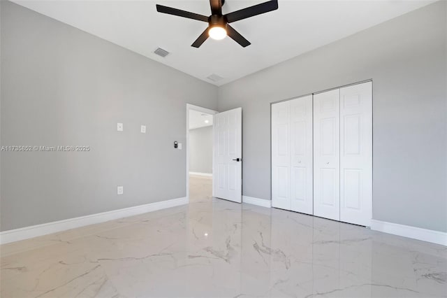 unfurnished bedroom with ceiling fan and a closet