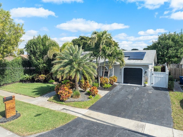 view of front of home featuring a front yard and solar panels