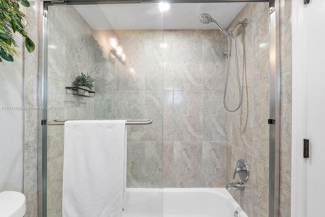 bathroom featuring combined bath / shower with glass door