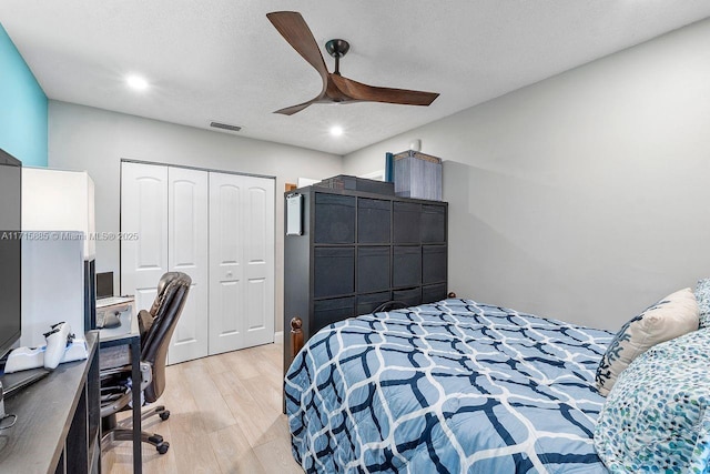 bedroom with ceiling fan, a closet, a textured ceiling, and light wood-type flooring