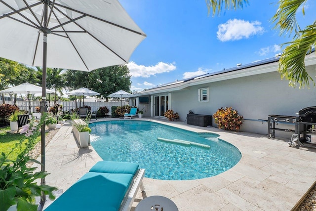 view of pool with area for grilling and a patio