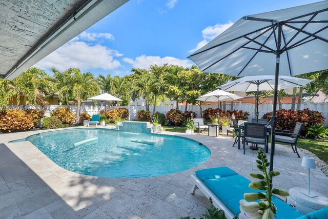 view of swimming pool with pool water feature and a patio