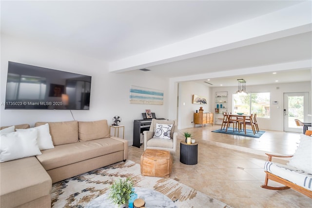 living room featuring beamed ceiling and light tile patterned floors