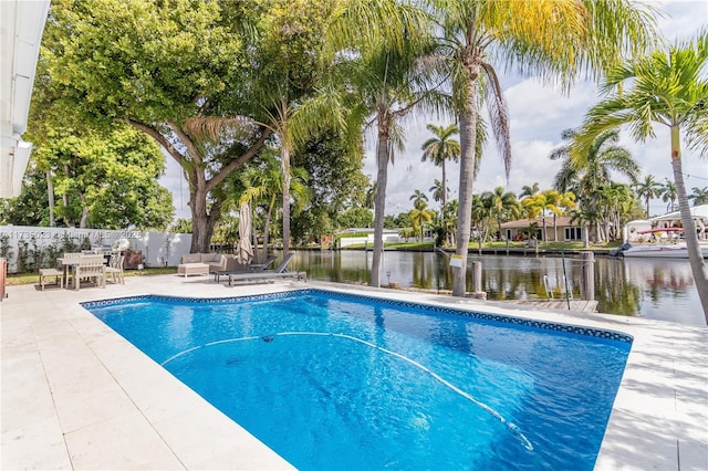 view of pool featuring a patio area and a water view