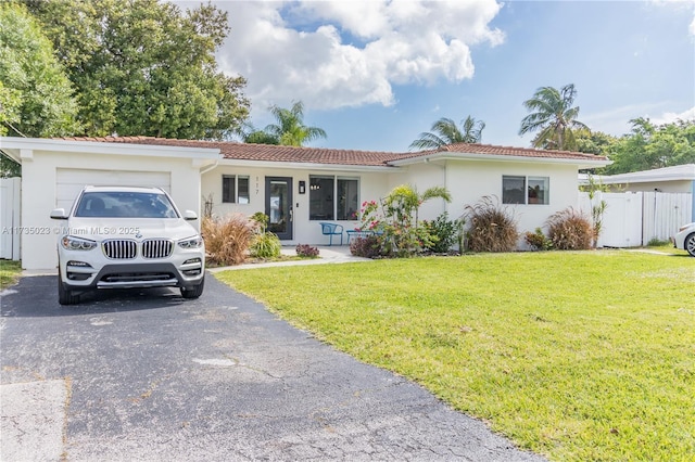 ranch-style house with a garage and a front lawn