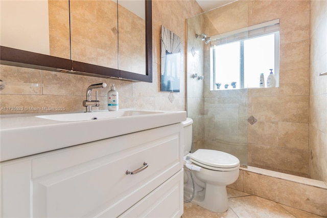 bathroom with tile walls, tiled shower, vanity, decorative backsplash, and toilet