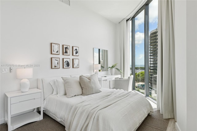 bedroom featuring a wall of windows and access to outside