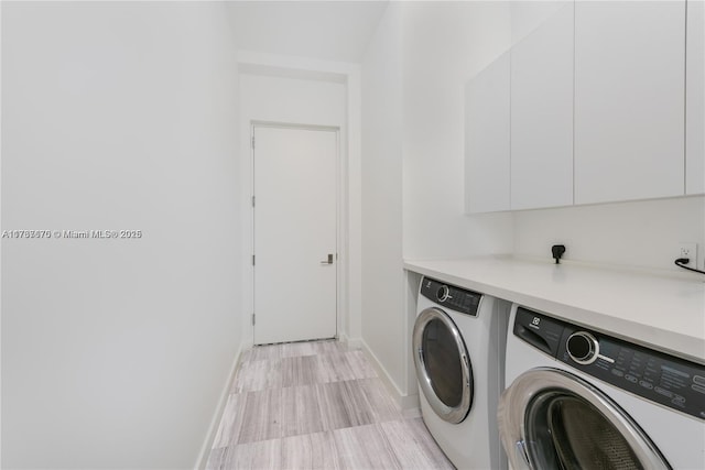 washroom with cabinets and washer and clothes dryer