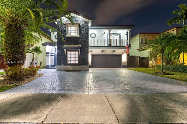 mediterranean / spanish-style house featuring a garage and a balcony