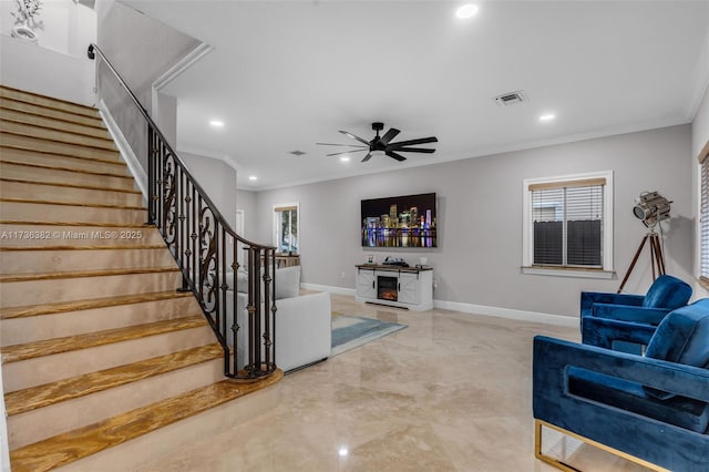 living room featuring ceiling fan, ornamental molding, and a wealth of natural light