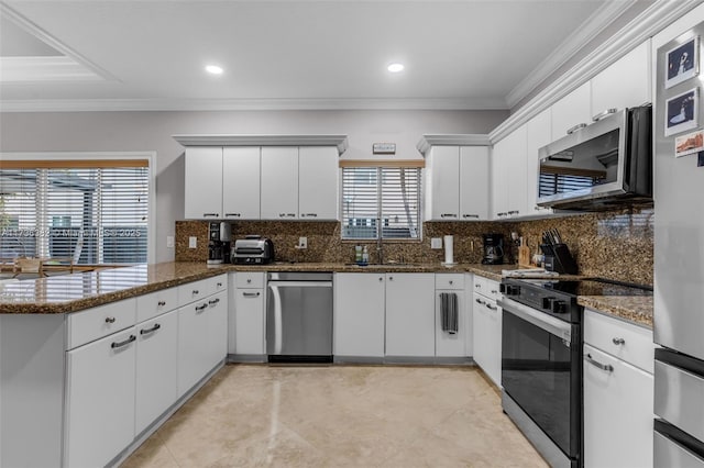 kitchen featuring stainless steel appliances, white cabinetry, and kitchen peninsula