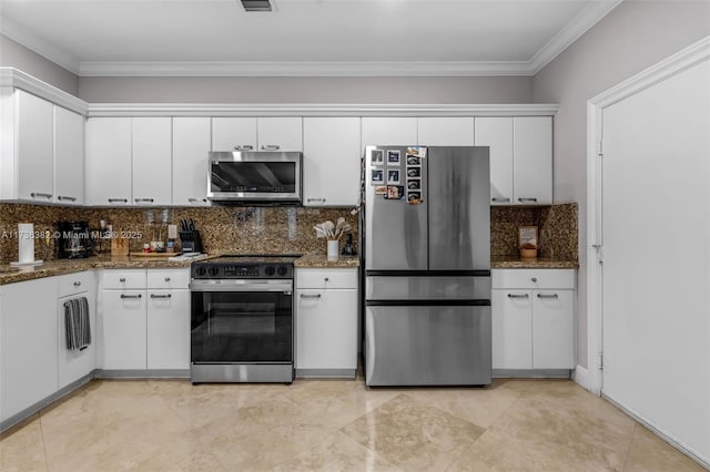 kitchen with dark stone countertops, white cabinetry, and stainless steel appliances