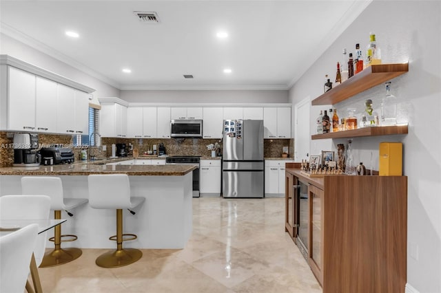 kitchen featuring white cabinetry, appliances with stainless steel finishes, sink, and dark stone counters