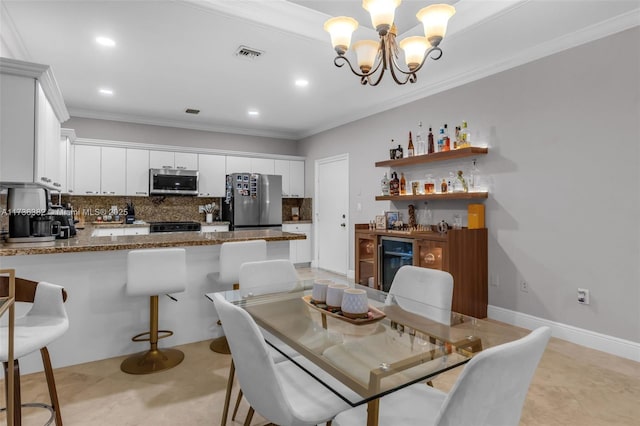 dining room with crown molding, an inviting chandelier, light tile patterned floors, indoor bar, and beverage cooler