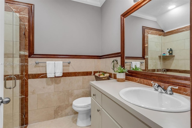 bathroom with toilet, a shower with shower door, tile walls, ornamental molding, and vanity