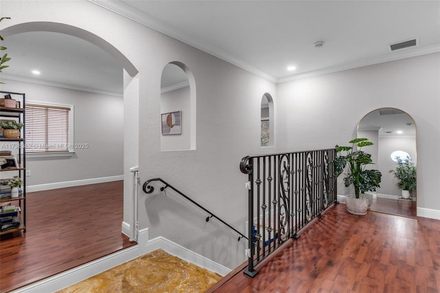 stairs with hardwood / wood-style floors and crown molding