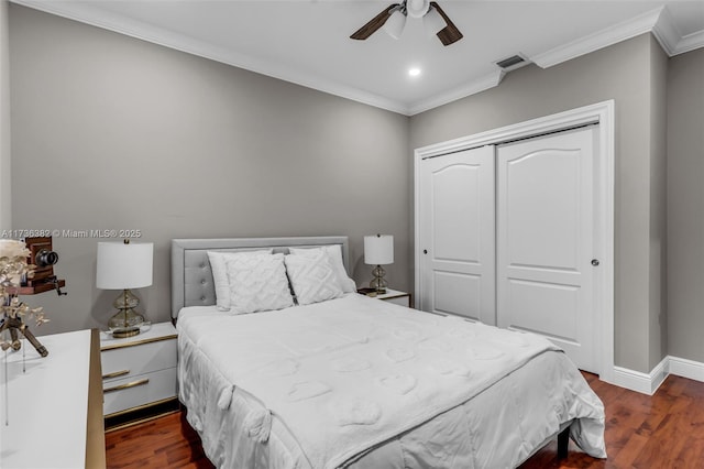 bedroom with dark hardwood / wood-style floors, ornamental molding, a closet, and ceiling fan