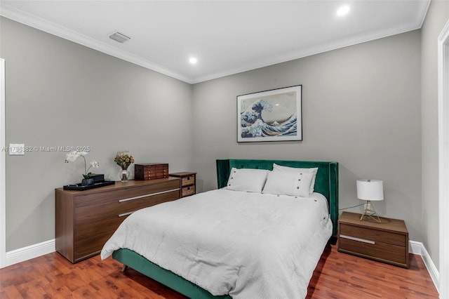 bedroom with dark hardwood / wood-style flooring and crown molding