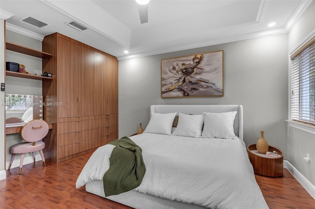 bedroom featuring hardwood / wood-style flooring, ornamental molding, and ceiling fan