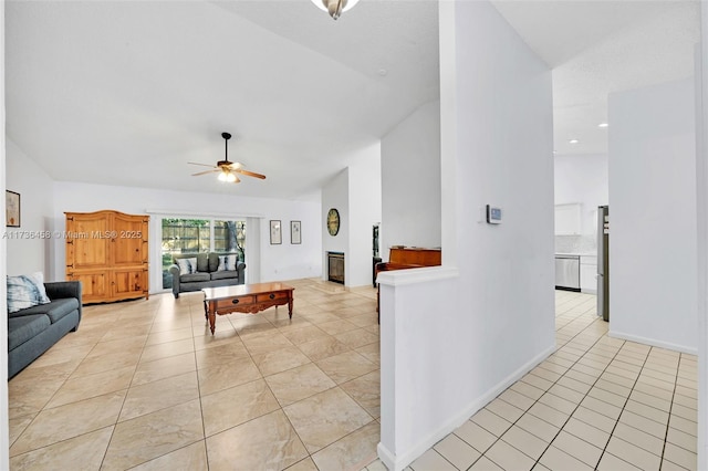 living room featuring vaulted ceiling, light tile patterned floors, and ceiling fan