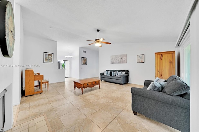 living room featuring ceiling fan, lofted ceiling, light tile patterned floors, and a textured ceiling