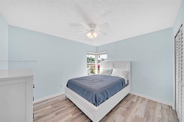 bedroom featuring ceiling fan, a textured ceiling, and light hardwood / wood-style floors