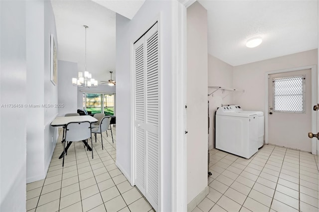 clothes washing area with light tile patterned flooring, separate washer and dryer, and a chandelier