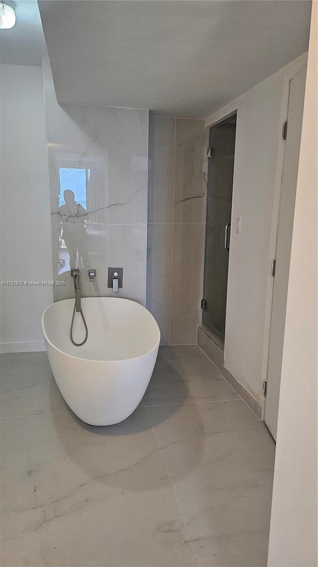 bathroom featuring independent shower and bath and tile walls