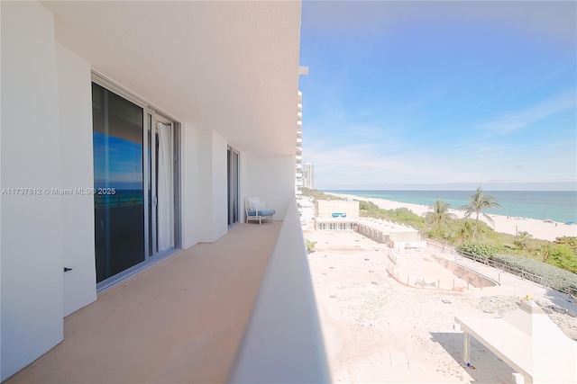 balcony featuring a water view and a view of the beach