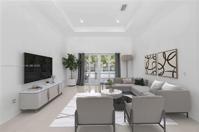 living room with a high ceiling, light tile patterned floors, recessed lighting, and a raised ceiling