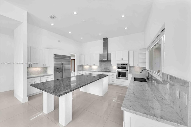 kitchen featuring stainless steel appliances, wall chimney exhaust hood, a spacious island, open shelves, and recessed lighting