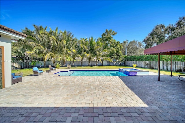 view of swimming pool featuring a patio area, a fenced backyard, and a pool with connected hot tub