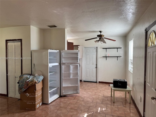 kitchen featuring ceiling fan, fridge, and a textured ceiling