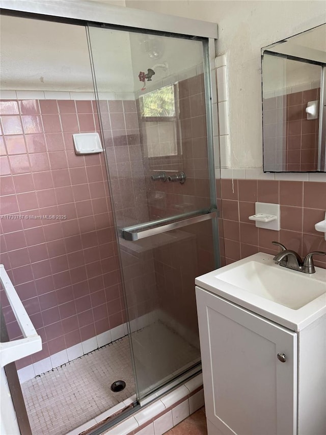 bathroom with vanity, tile walls, and an enclosed shower