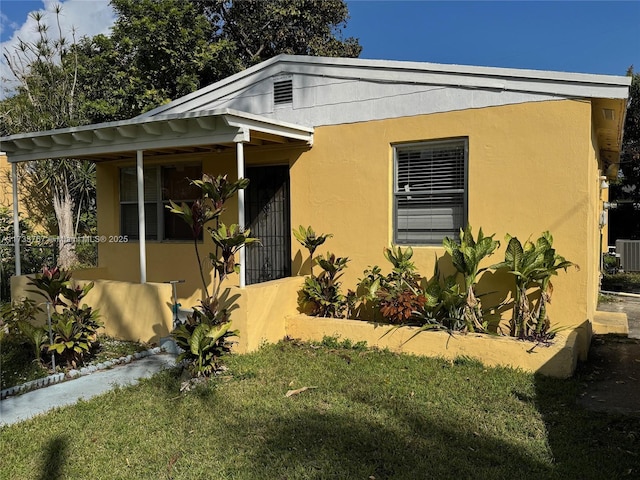 view of front of home featuring a front lawn and central air condition unit